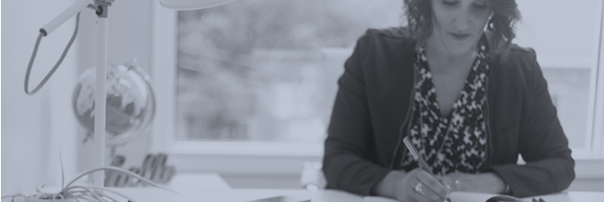 Image of a woman writing on a piece of paper