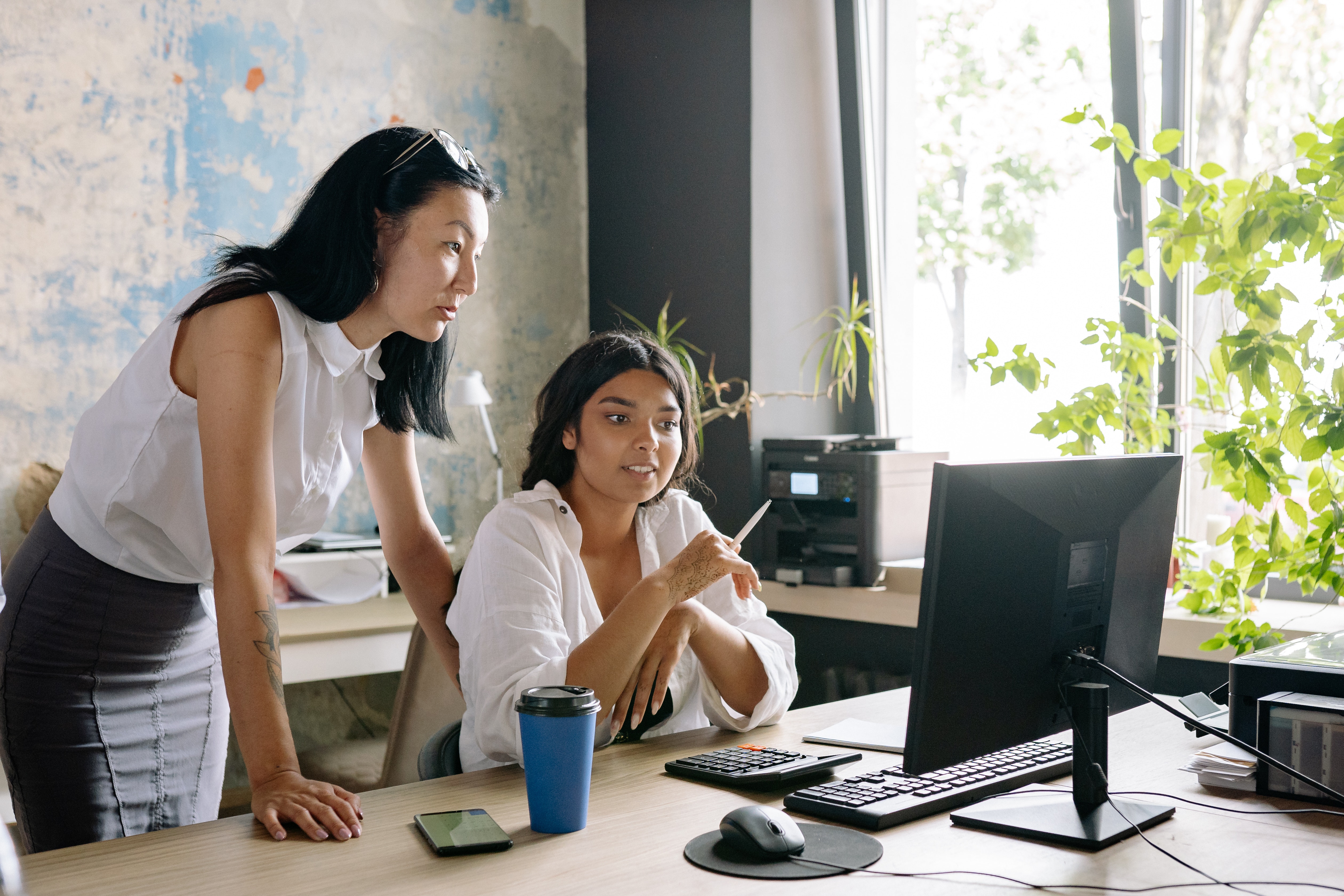 A legal writing instructor and a student look at a computer together reviewing the student's writing.