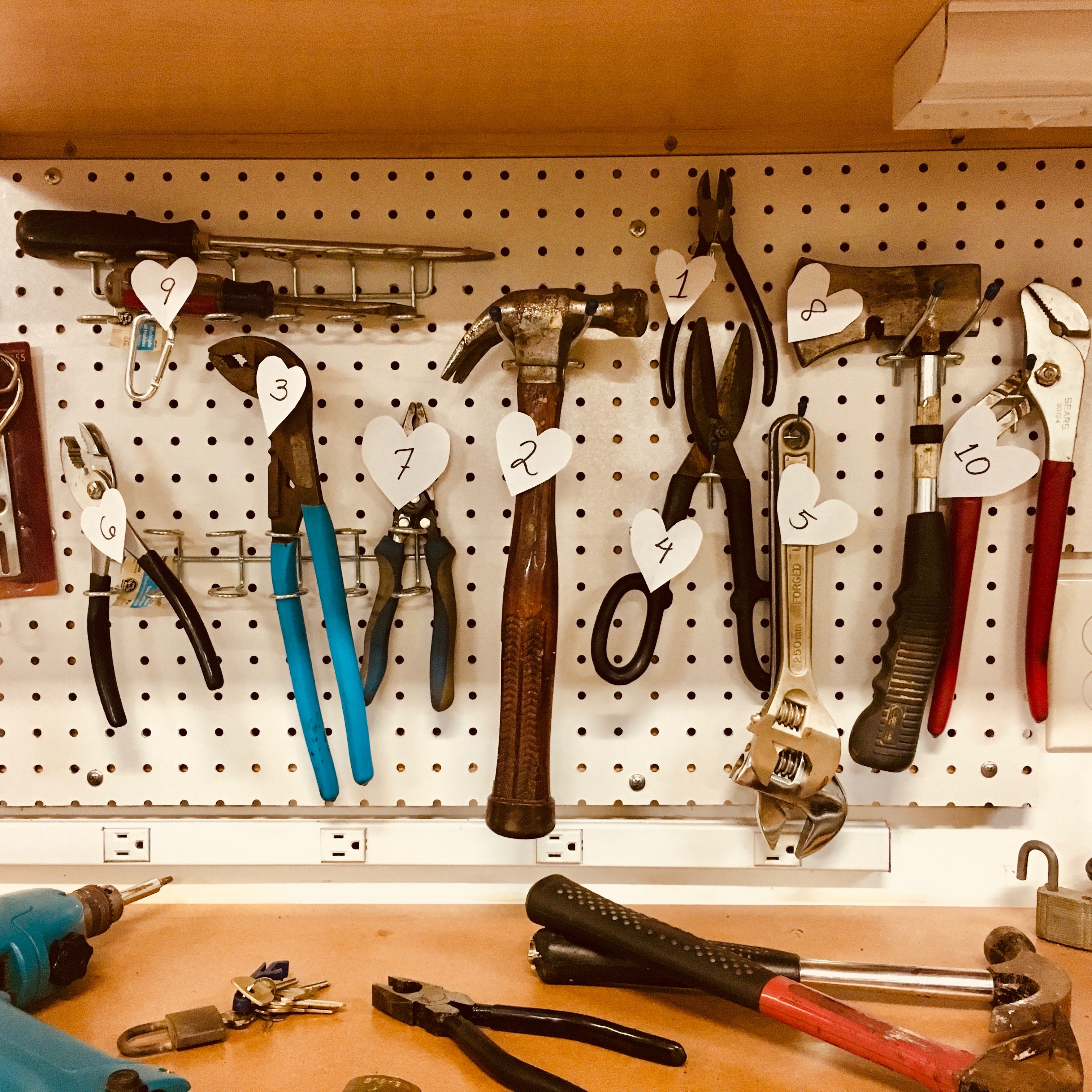 A workshop wall has each tool labeled with a tag with a different number.