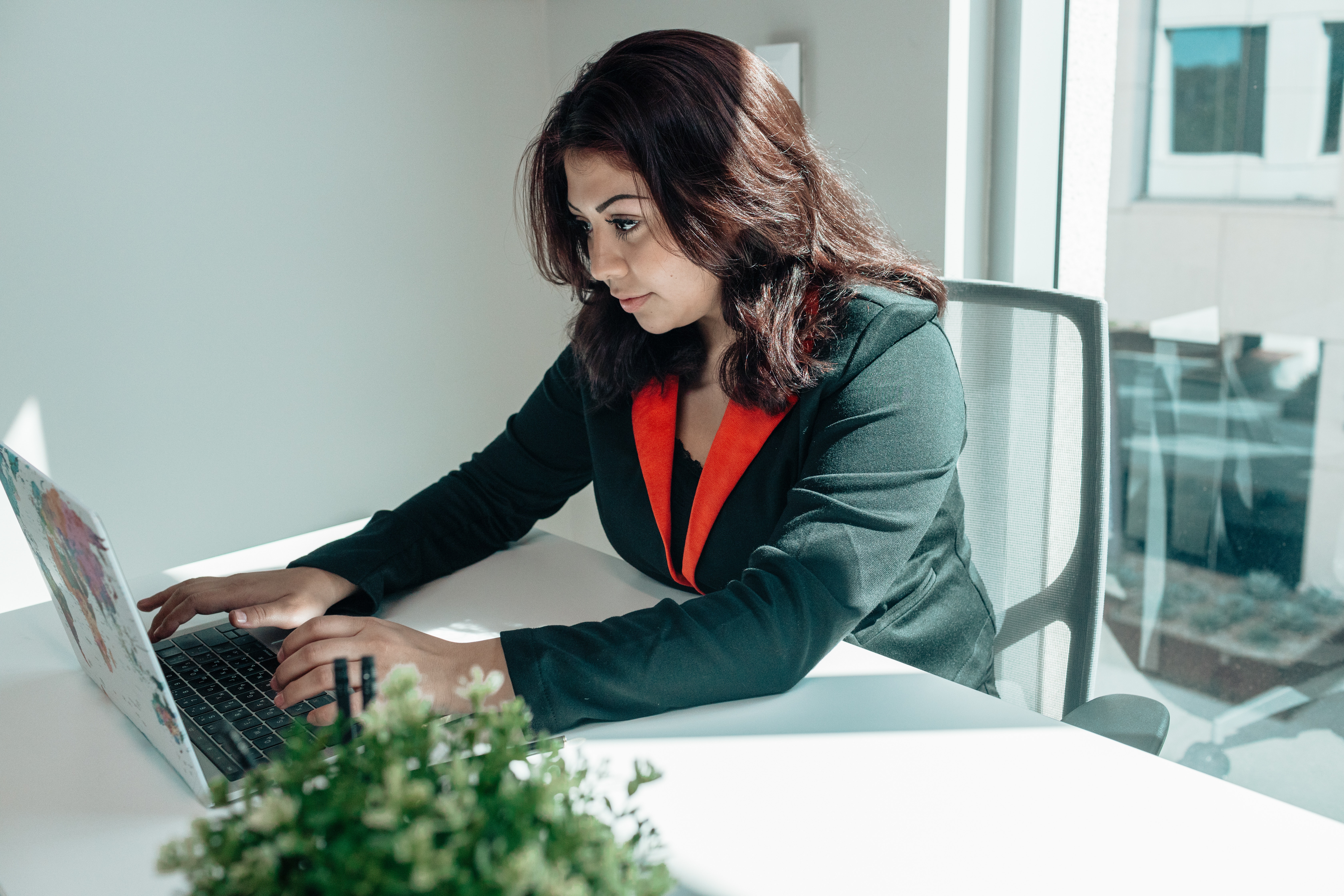 A paralegal sits in her office, focused on typing a document on her computer