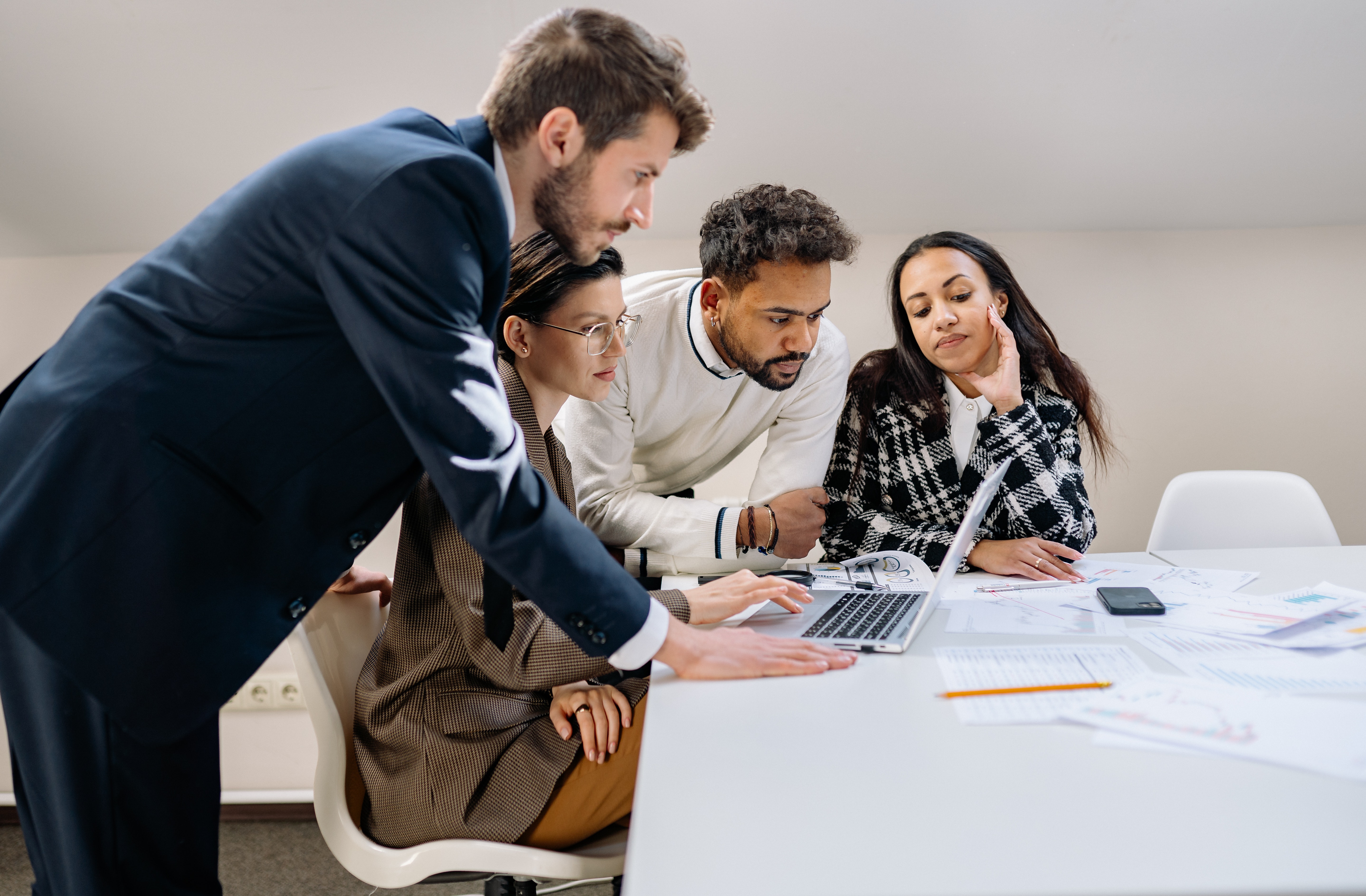 A marketing is huddled around a computer looking at a marketing report together.