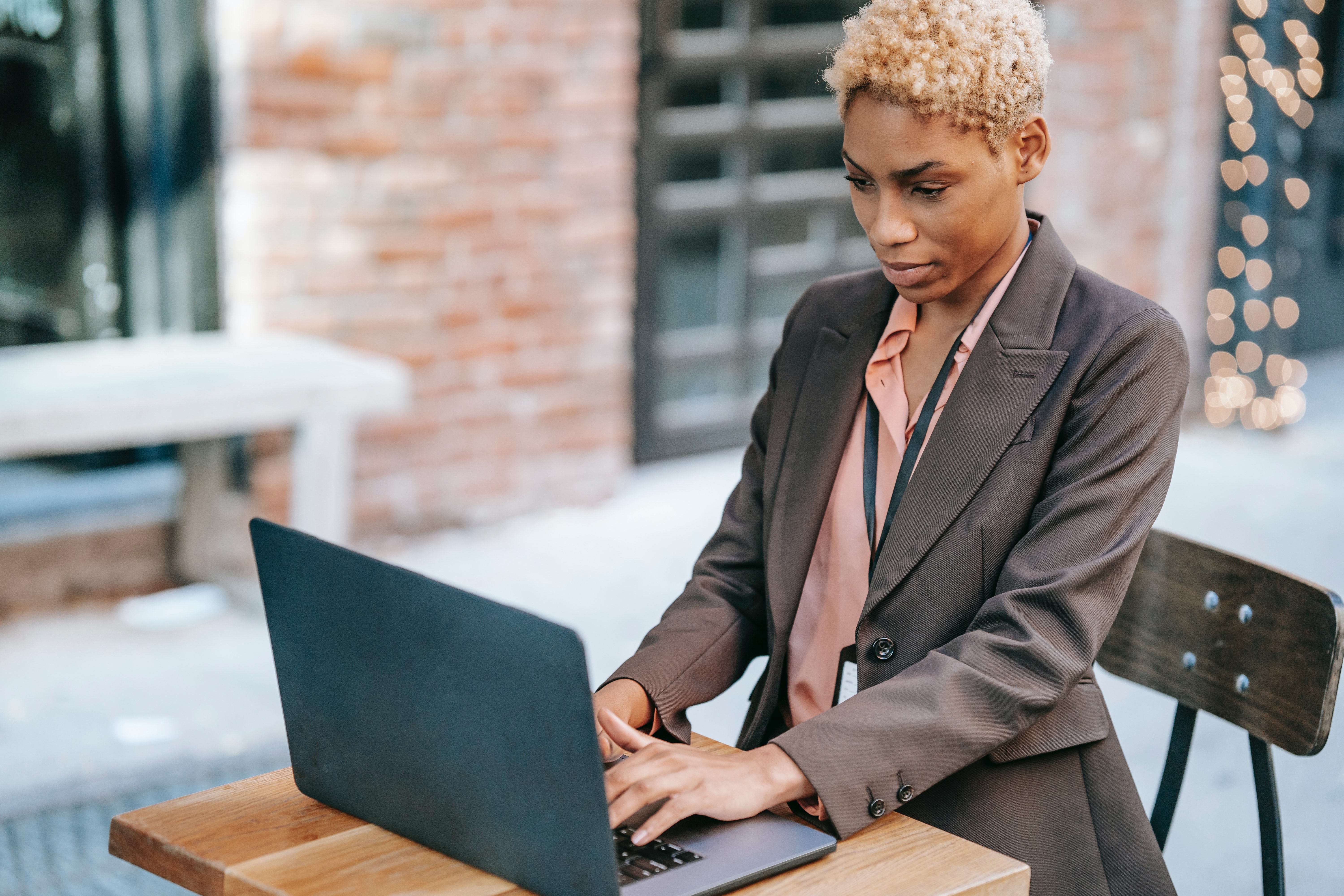 A confident paralegal stands typing on her computer at a bar-height table.