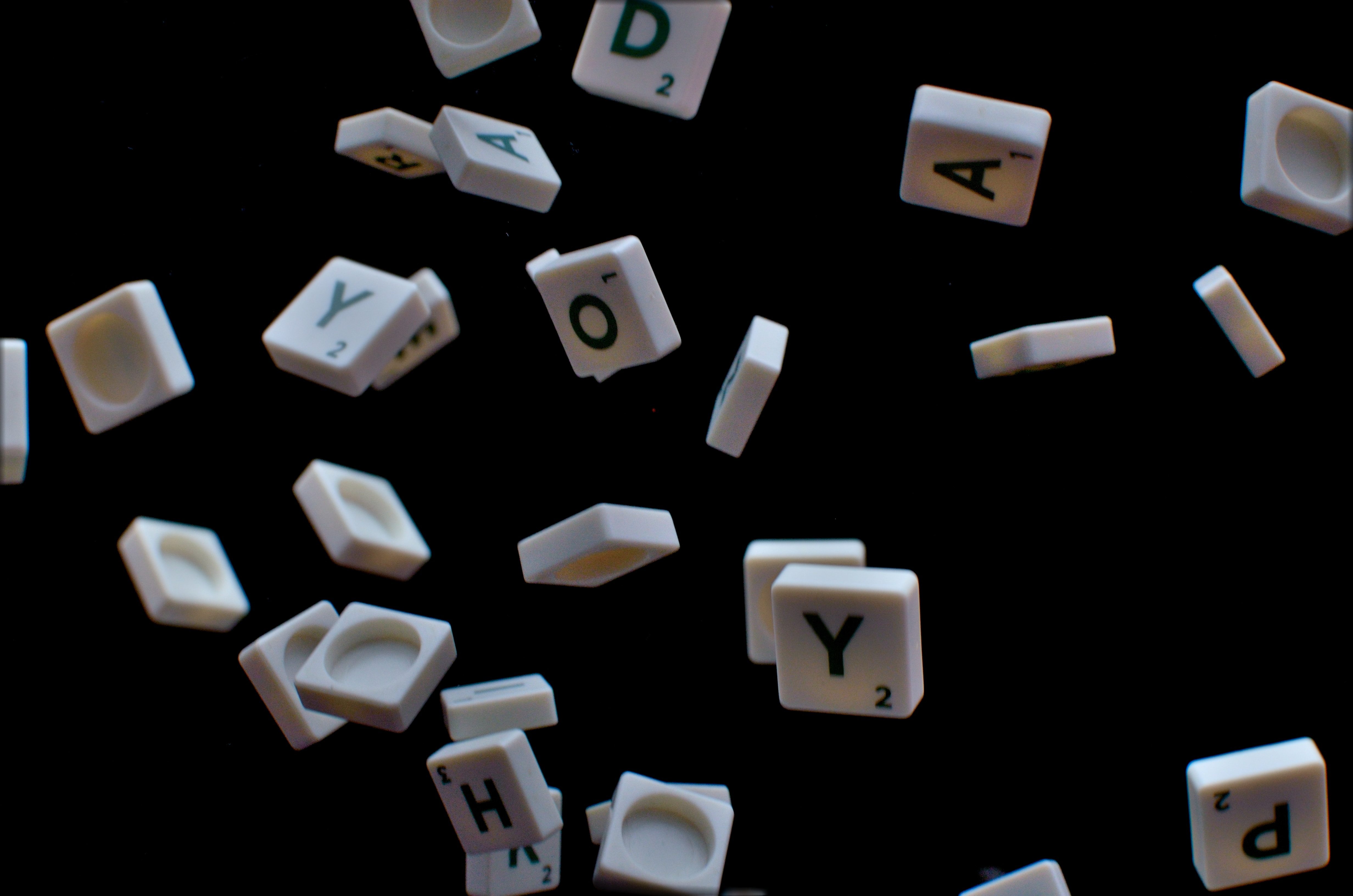 Scrabble tiles falling through black space